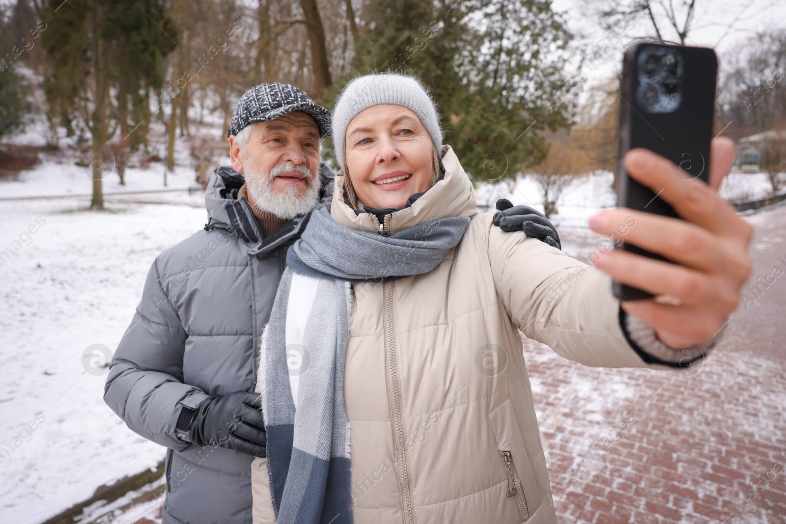 Photo of Happy senior couple taking selfie at winter park