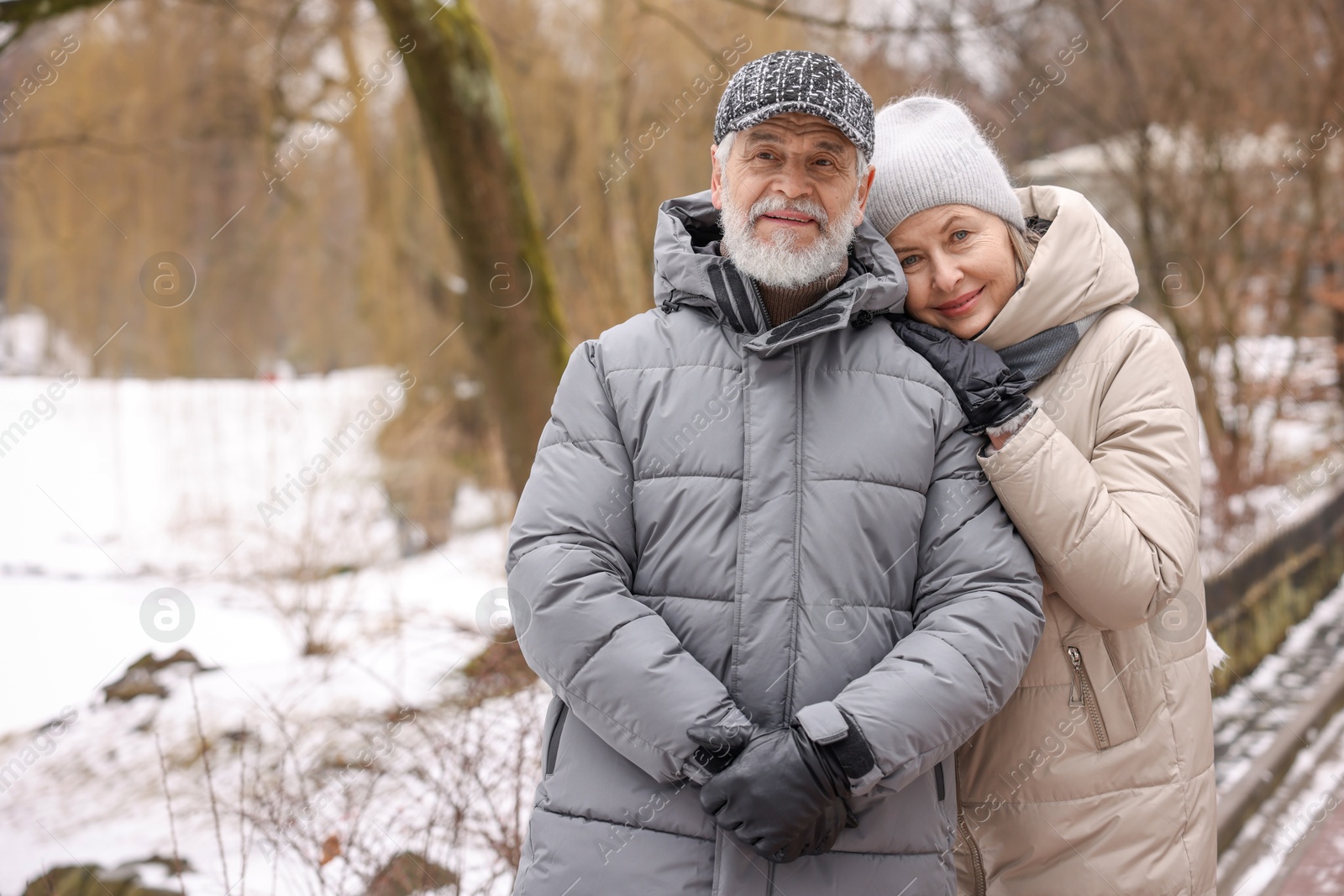 Photo of Portrait of happy senior couple at winter park. Space for text