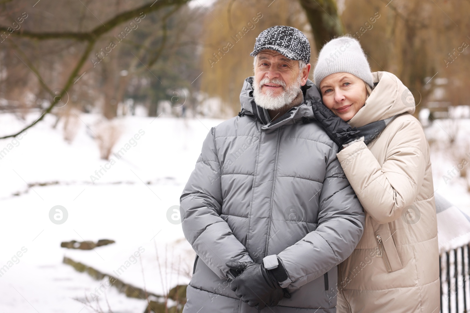 Photo of Portrait of happy senior couple at winter park. Space for text