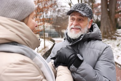 Photo of Lovely senior couple holding hands at winter park