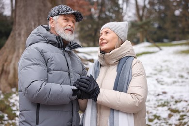 Photo of Lovely senior couple holding hands at winter park