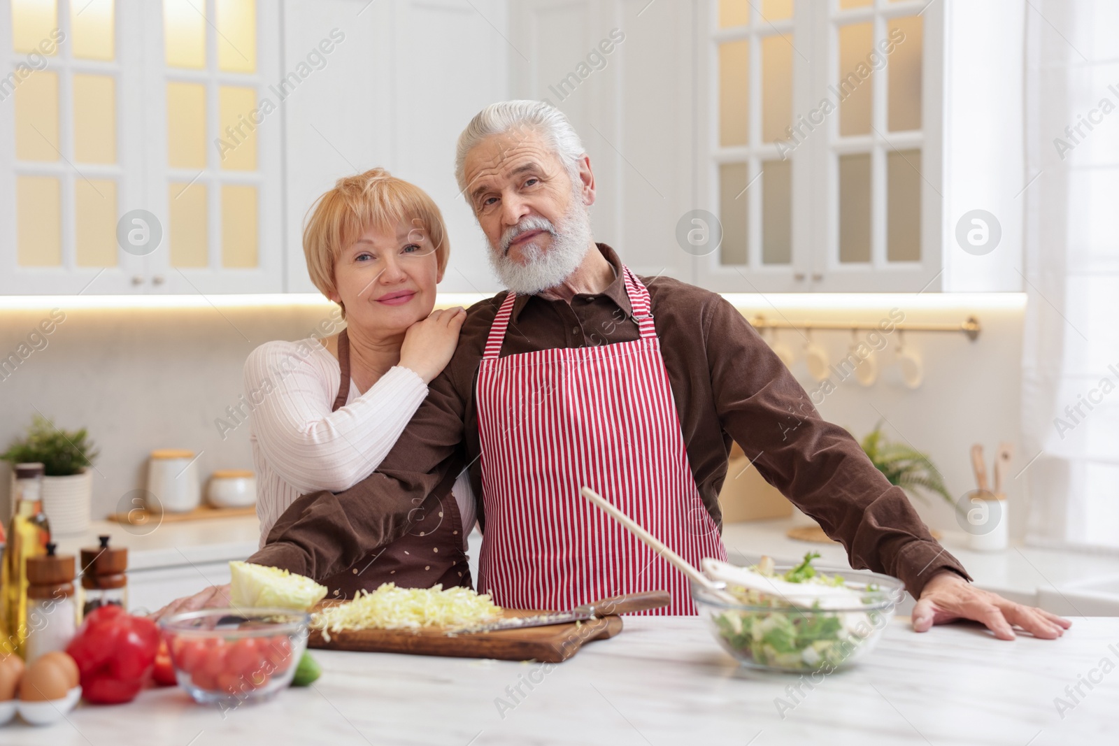 Photo of Senior couple cooking together at table in kitchen