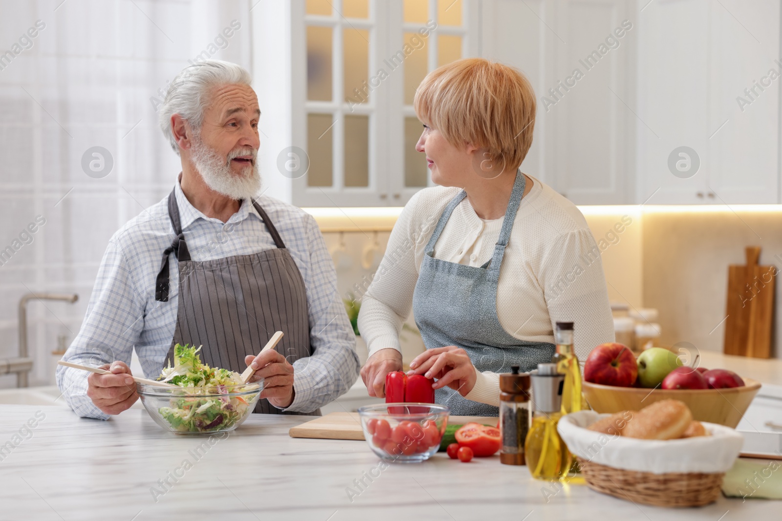 Photo of Senior couple cooking together at table in kitchen