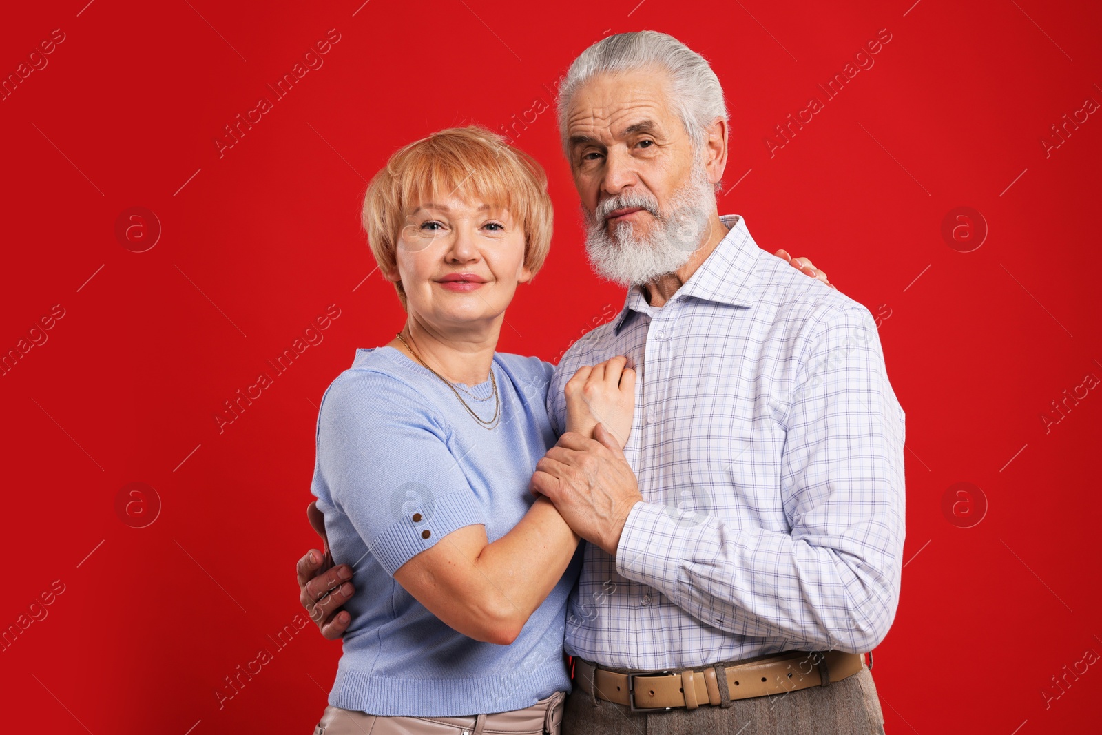 Photo of Portrait of lovely senior couple on red background