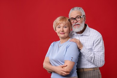 Photo of Portrait of lovely senior couple on red background. Space for text