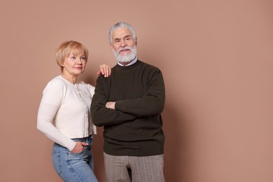 Photo of Lovely senior couple on beige background. Space for text