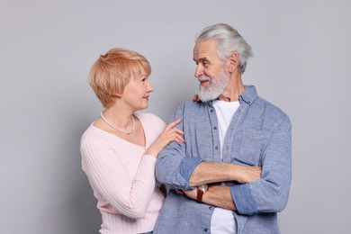 Photo of Lovely senior couple looking at each other on grey background