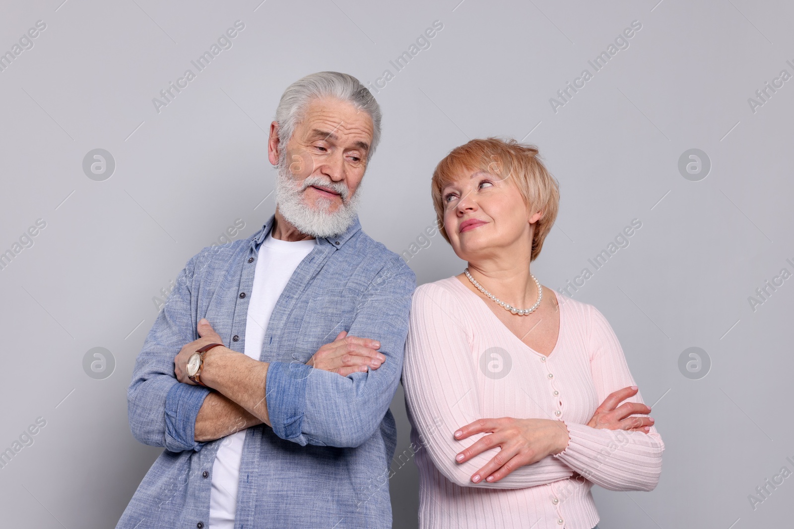 Photo of Lovely senior couple looking at each other on grey background