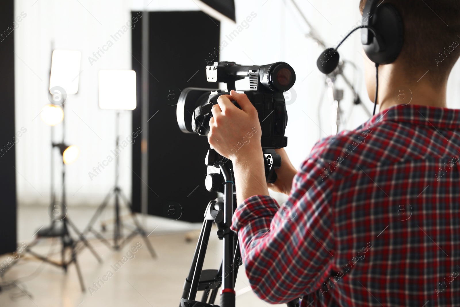 Photo of Man with professional video camera in studio, space for text