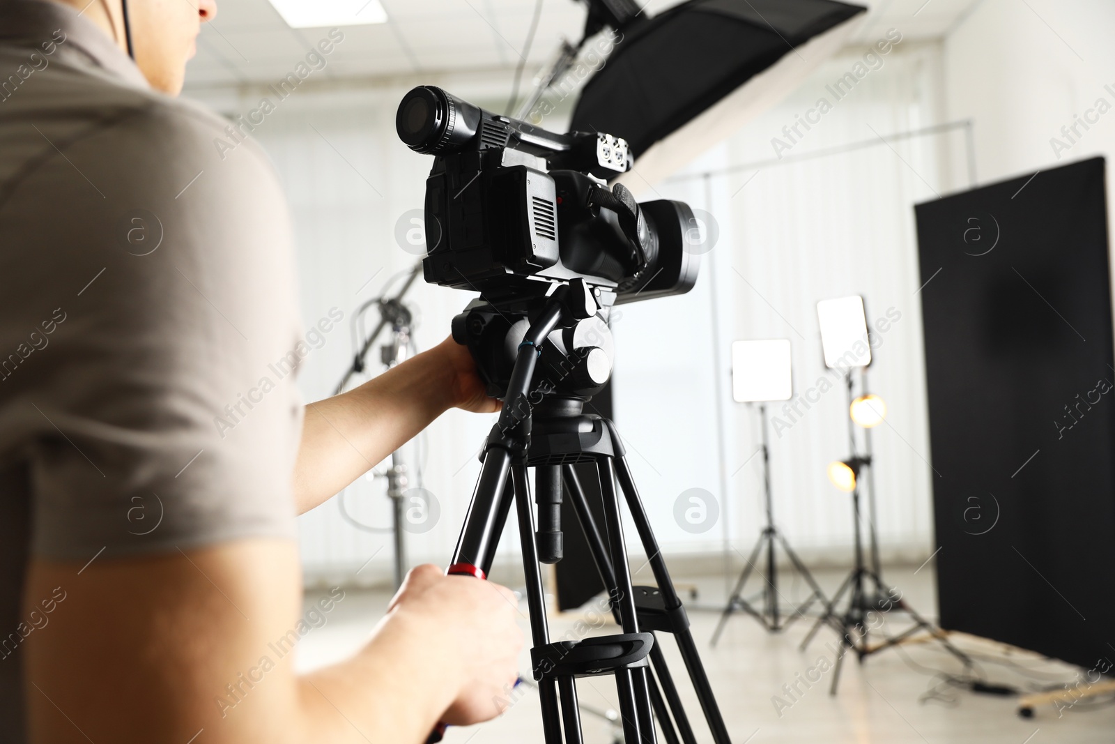 Photo of Man with professional video camera in studio, closeup. Space for text