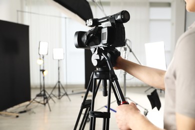 Photo of Man with professional video camera in studio, closeup. Space for text