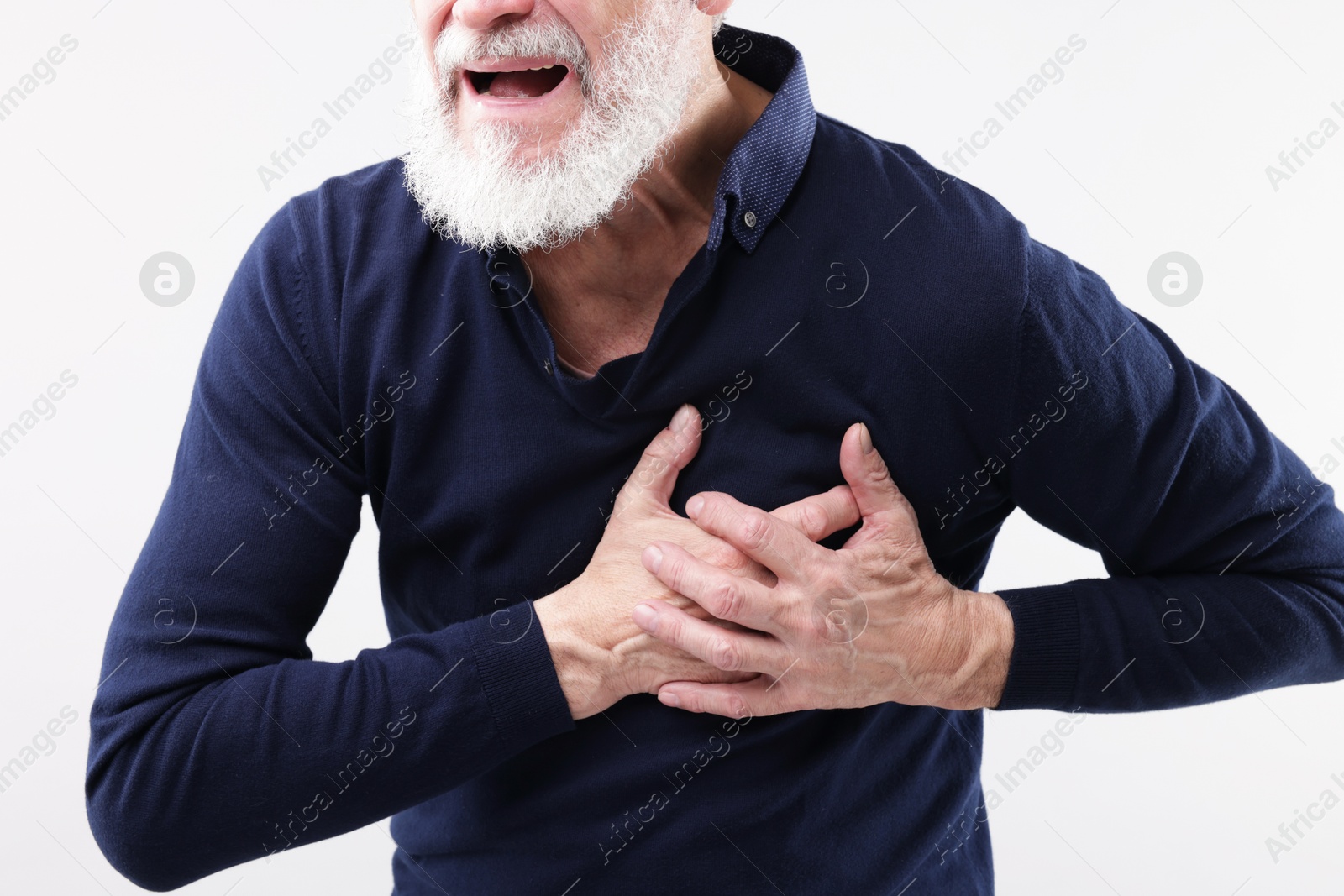 Photo of Heart attack. Senior man suffering from pain in chest on light background, closeup