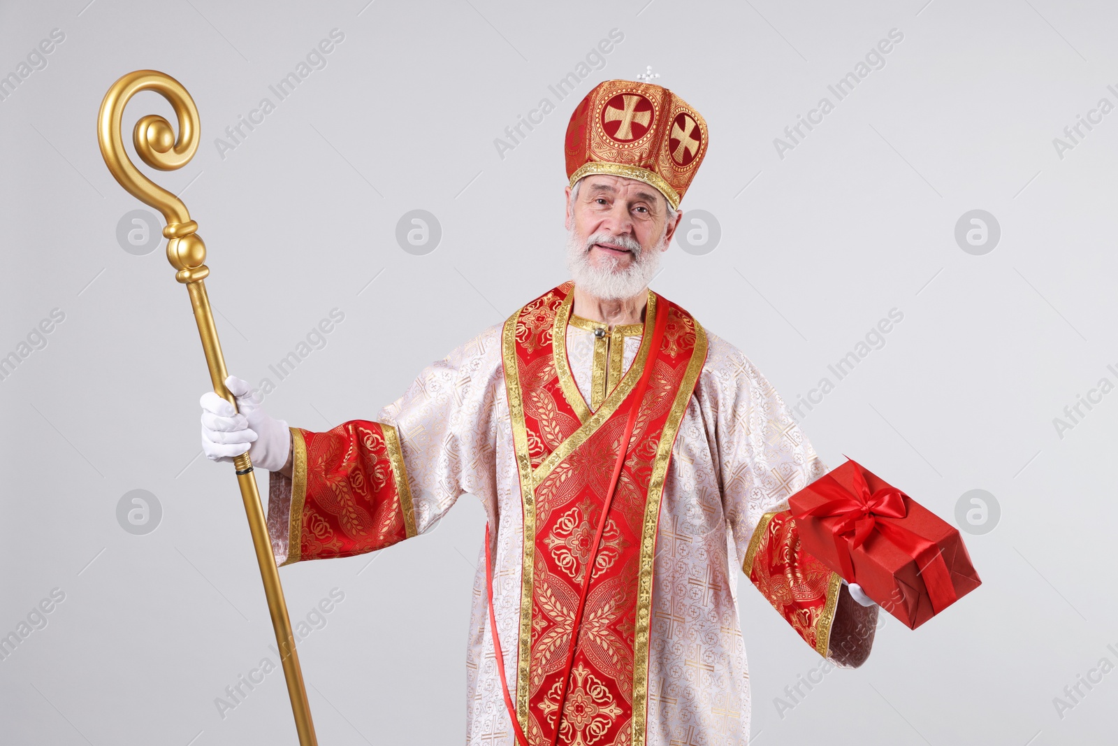 Photo of Saint Nicholas with gift on light grey background