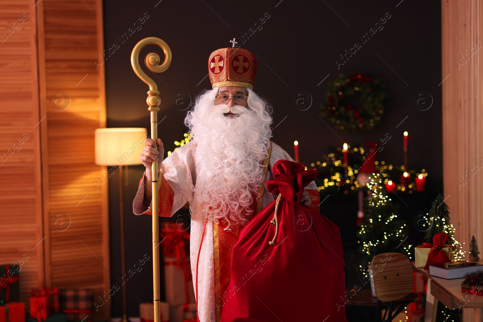 Photo of Saint Nicholas with sack in room decorated for Christmas