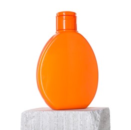 Photo of Bottle of sun protection product on concrete block against white background