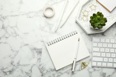 Photo of Paper clips, other stationery, decor and computer keyboard on white marble table, flat lay. Space for text