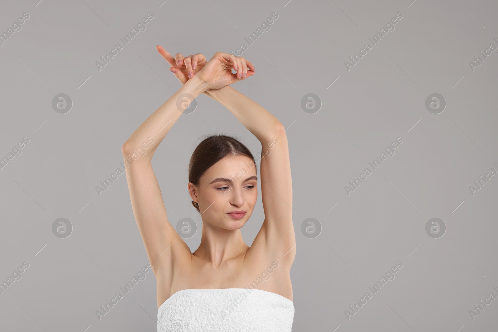 Photo of Young woman showing smooth skin after epilation on gray background, space for text