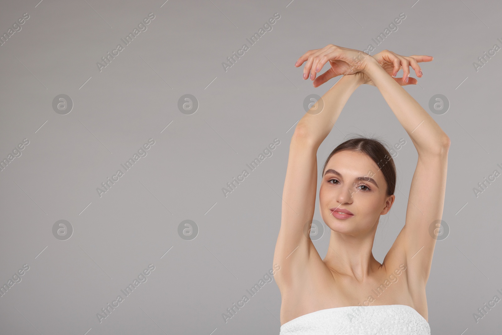 Photo of Young woman showing smooth skin after epilation on gray background, space for text