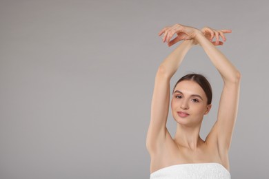 Photo of Young woman showing smooth skin after epilation on gray background, space for text