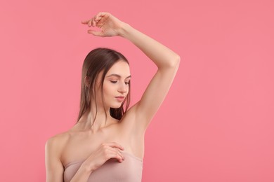 Photo of Young woman showing smooth skin after epilation on pink background, space for text