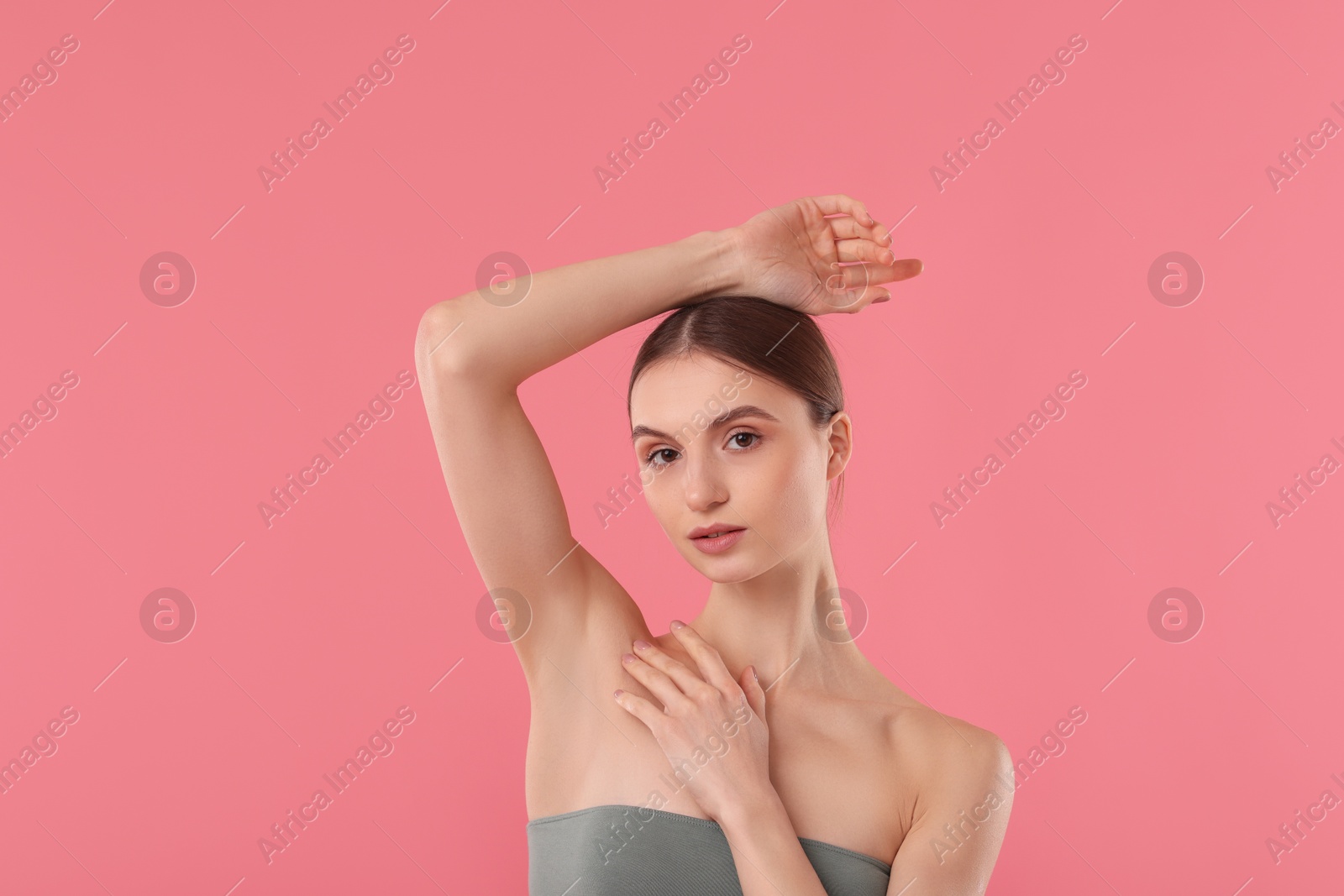 Photo of Young woman showing smooth skin after epilation on pink background