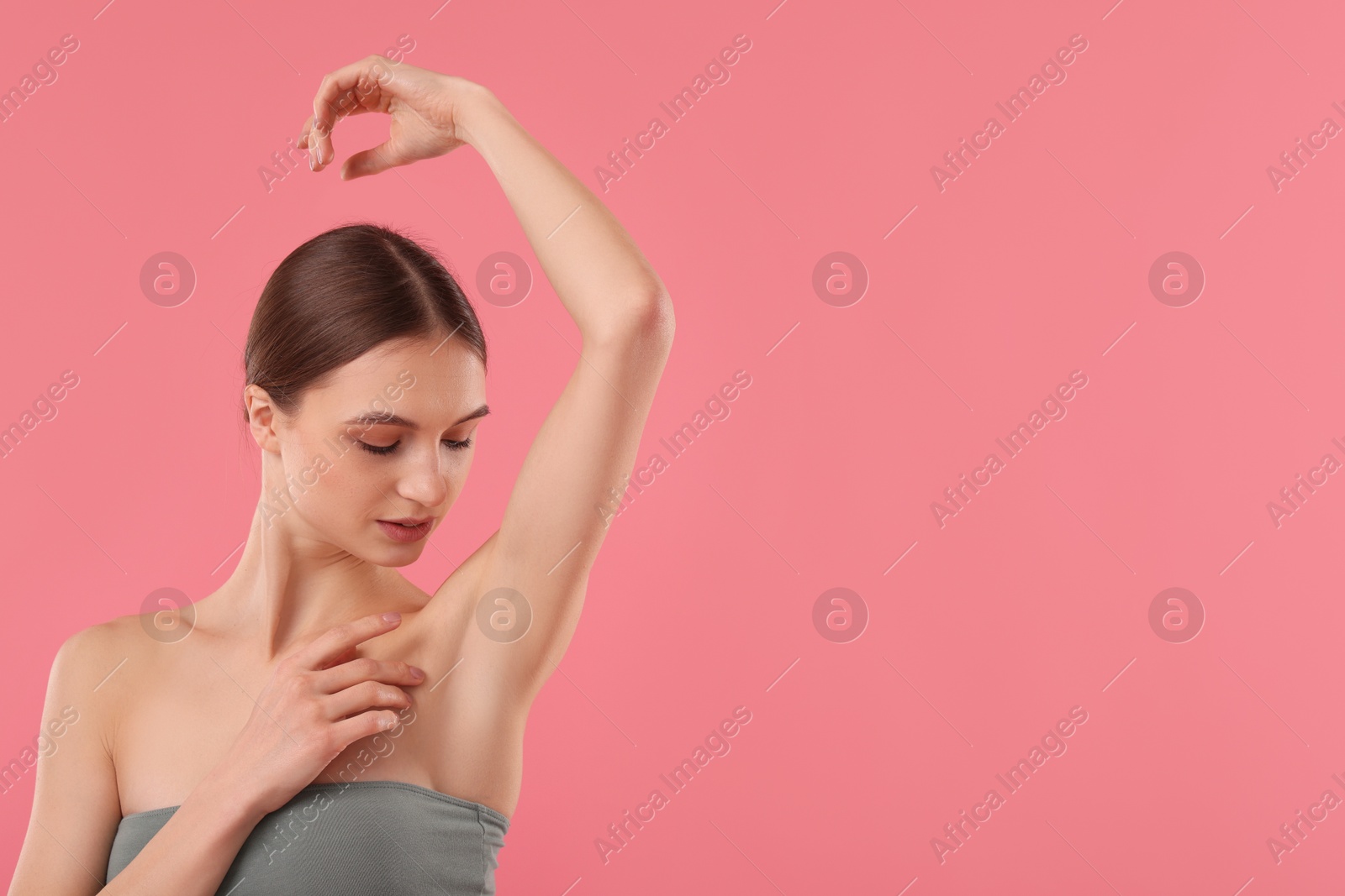 Photo of Young woman showing smooth skin after epilation on pink background, space for text