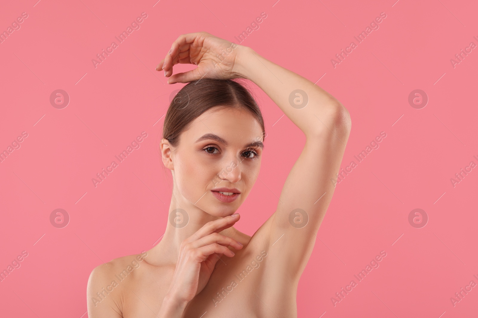 Photo of Young woman showing smooth skin after epilation on pink background