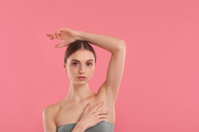 Photo of Young woman showing smooth skin after epilation on pink background