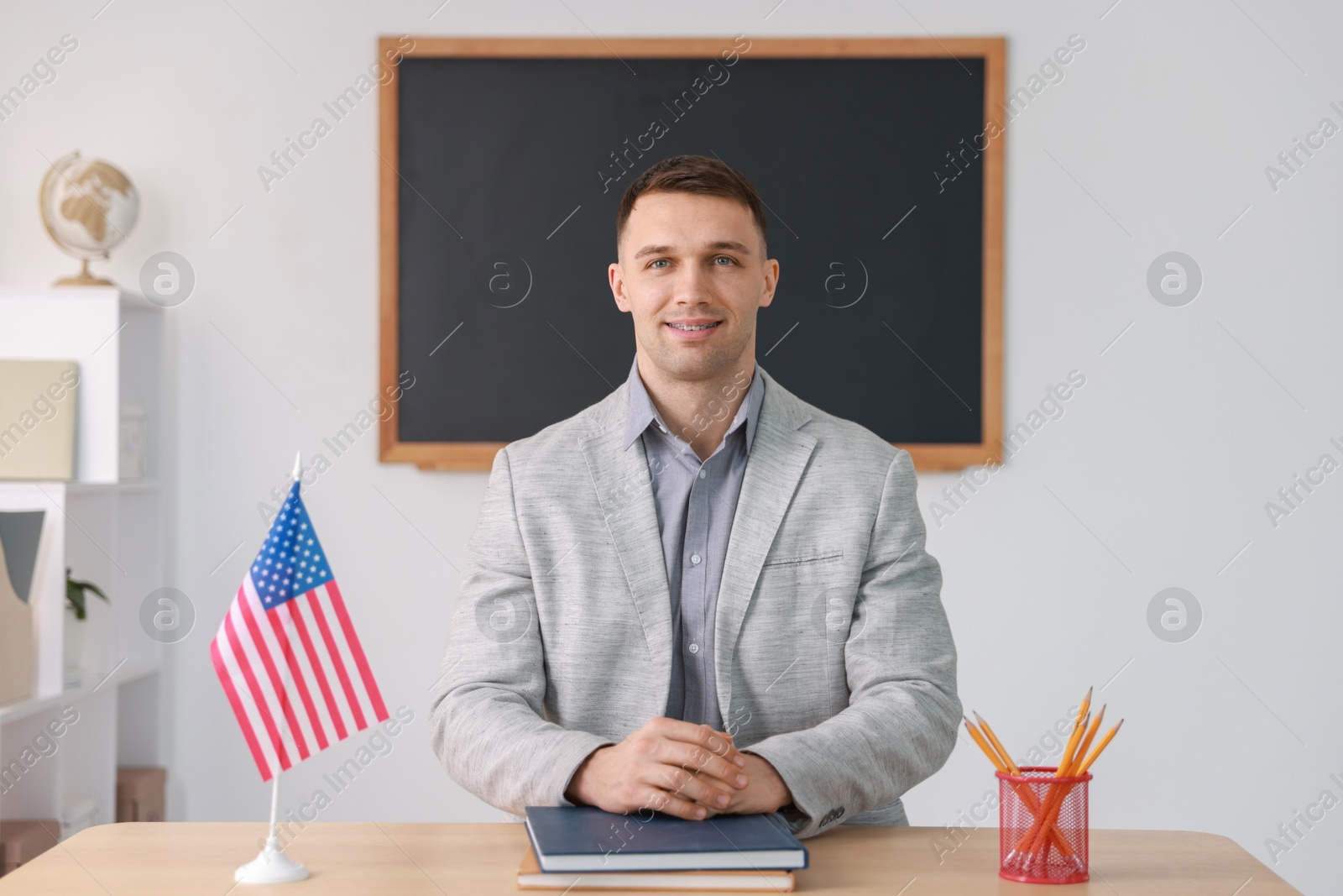 Photo of English teacher working at desk in classroom