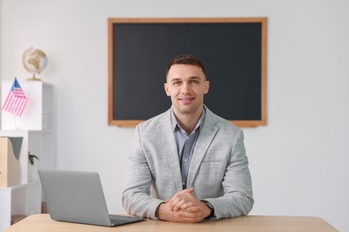 Photo of English teacher working at desk in classroom