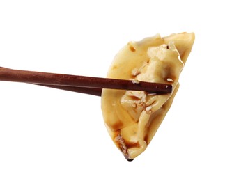 Photo of Chopsticks with tasty boiled gyoza (dumpling) on white background