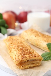 Photo of Tasty apple strudels and mint on table, closeup