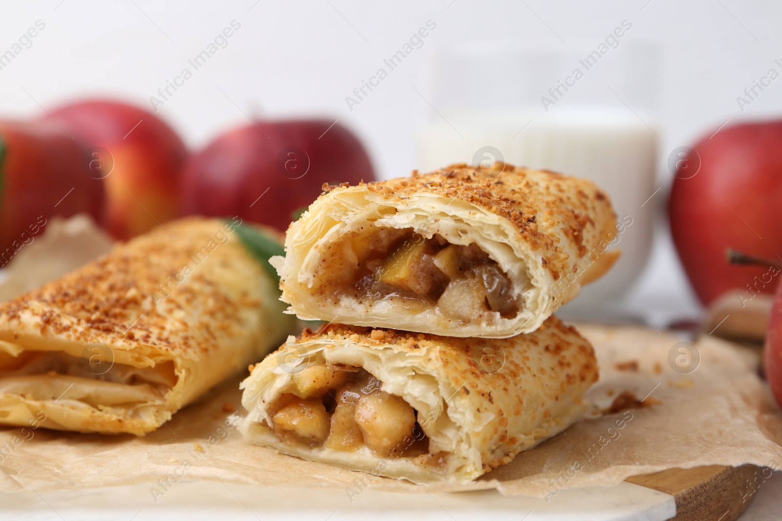 Photo of Tasty strudels with apples on table, closeup