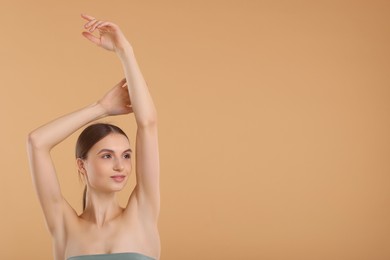 Photo of Young woman showing smooth skin after epilation on beige background, space for text