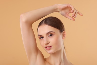 Photo of Young woman showing smooth skin after epilation on beige background