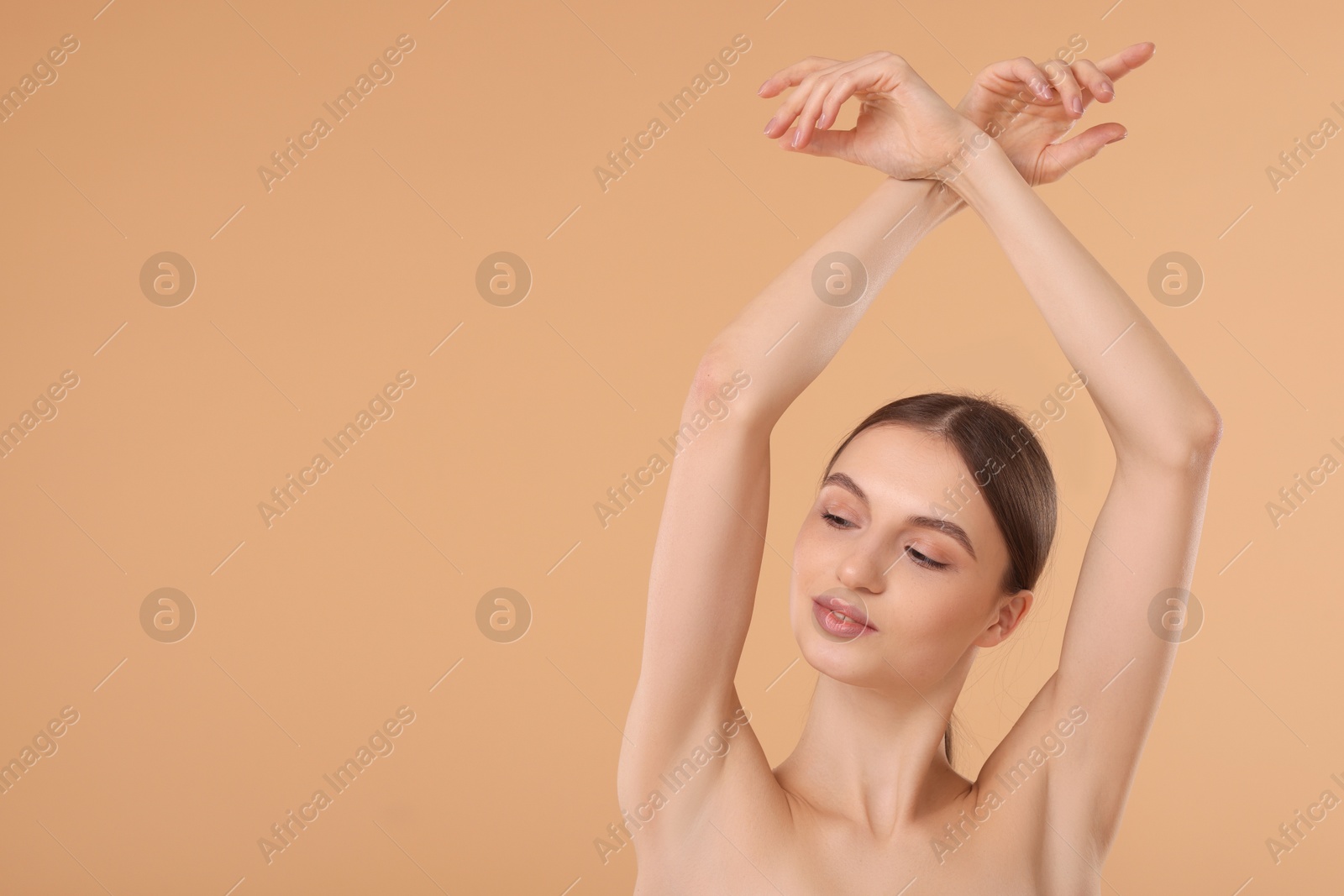 Photo of Young woman showing smooth skin after epilation on beige background, space for text