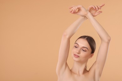 Photo of Young woman showing smooth skin after epilation on beige background, space for text