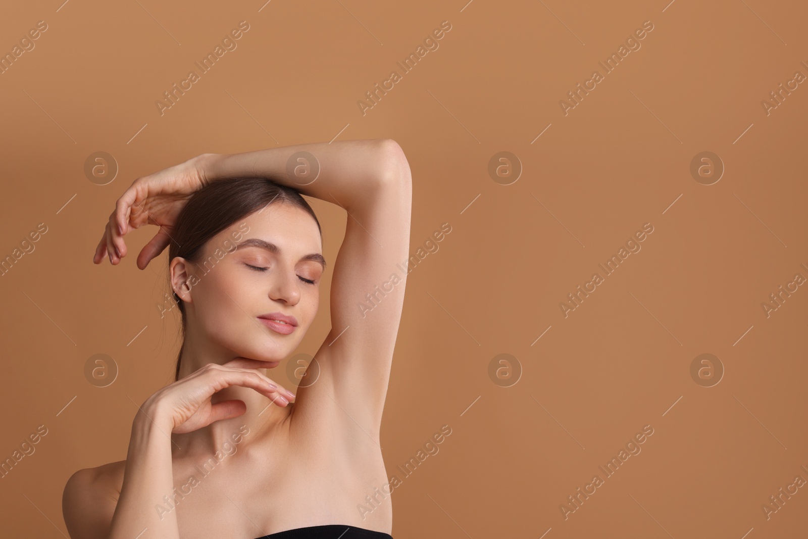 Photo of Young woman showing smooth skin after epilation on beige background, space for text