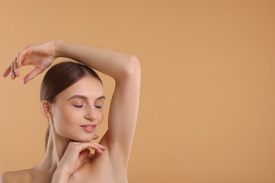 Photo of Young woman showing smooth skin after epilation on beige background, space for text