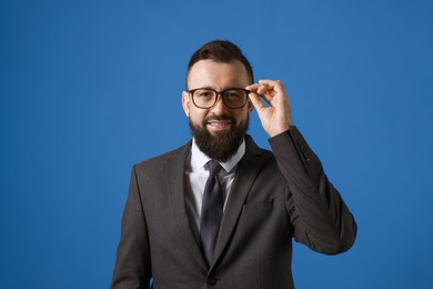 Photo of Handsome bearded man in suit on blue background