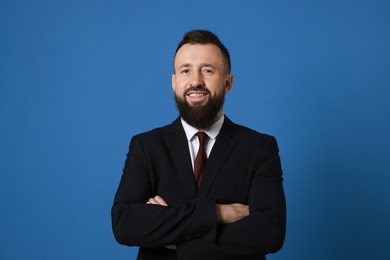 Photo of Handsome bearded man in suit on blue background