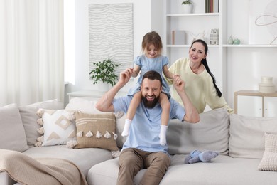 Photo of Cute little girl and her parents having fun at home