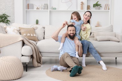 Photo of Cute little girl and her parents having fun at home