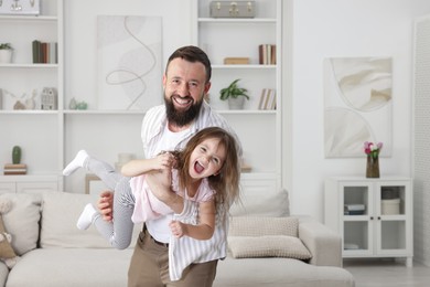 Photo of Cute little girl and her father having fun at home