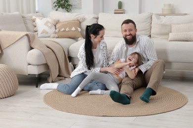 Photo of Cute little girl and her parents having fun at home