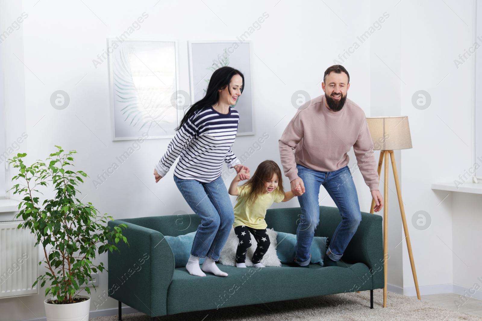 Photo of Cute little girl and her parents having fun at home