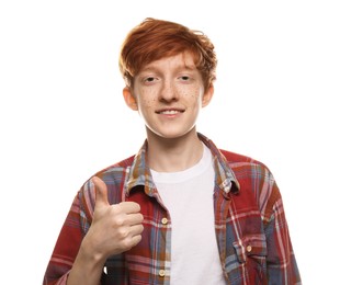 Smiling teenage boy with freckles showing thumbs up on white background