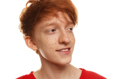 Smiling teenage boy with freckles on white background