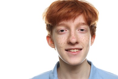 Portrait of smiling teenage boy with freckles on white background