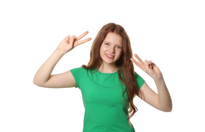 Photo of Beautiful teenage girl with freckles showing V-sign on white background